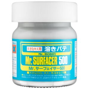 Mr. Surfacer 500 jar: essential gray primer for model builders, featuring bold labeling and safety symbols.